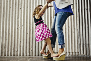Image of small girl walking on mother's feet