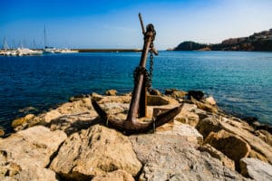 Large anchor on rocky shore