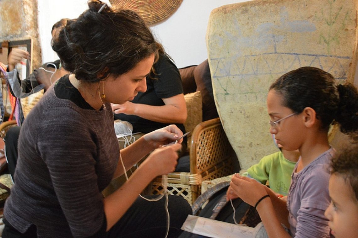 Woman teaching girl to knit