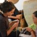 Woman teaching girl to knit