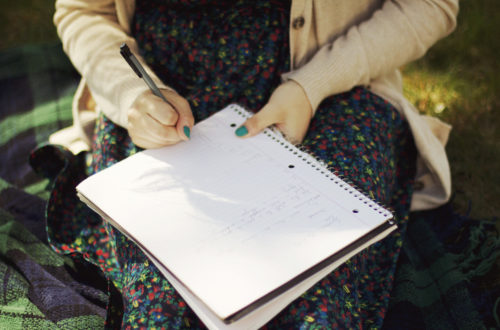 Image of woman writing in journal on her lap