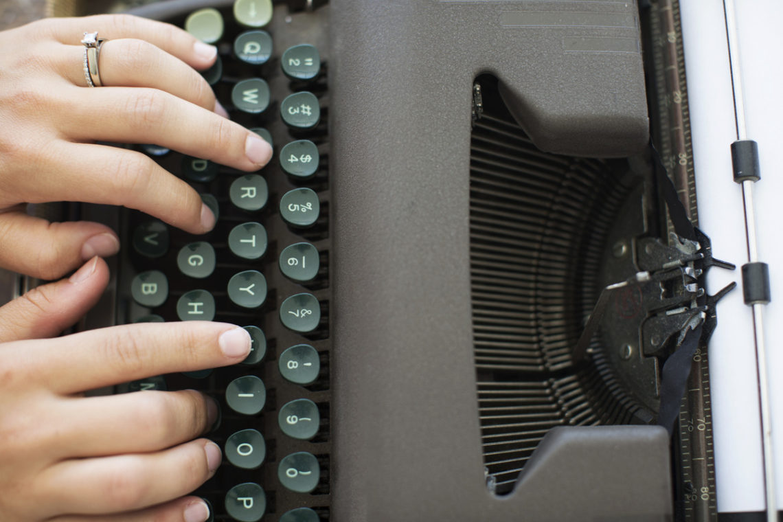 Image of hands and vintage typewriter keys