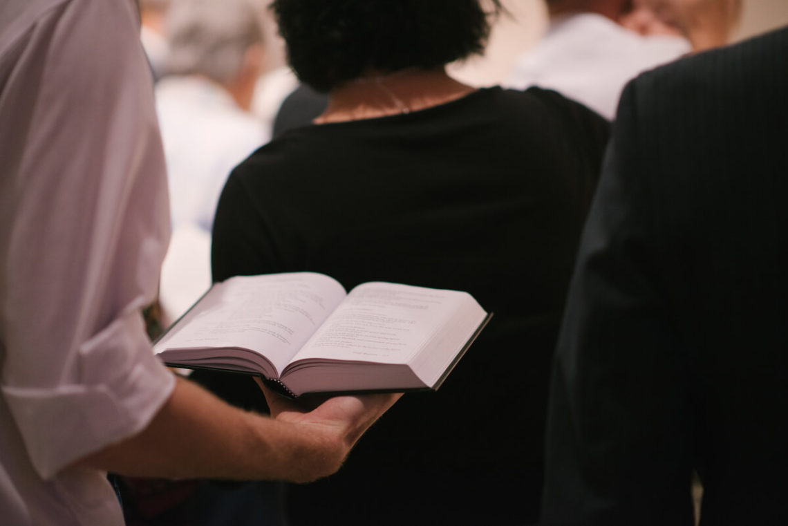 Image of man holding hymnbook