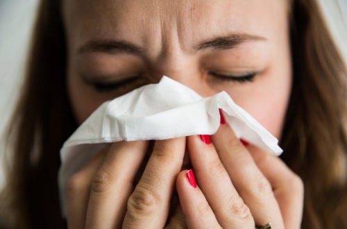 Image of woman holding tissue to nose