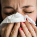 Image of woman holding tissue to nose