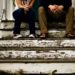 man_and_woman_sitting_on_wooden_steps