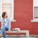 Young woman sitting on concrete bench, waiting