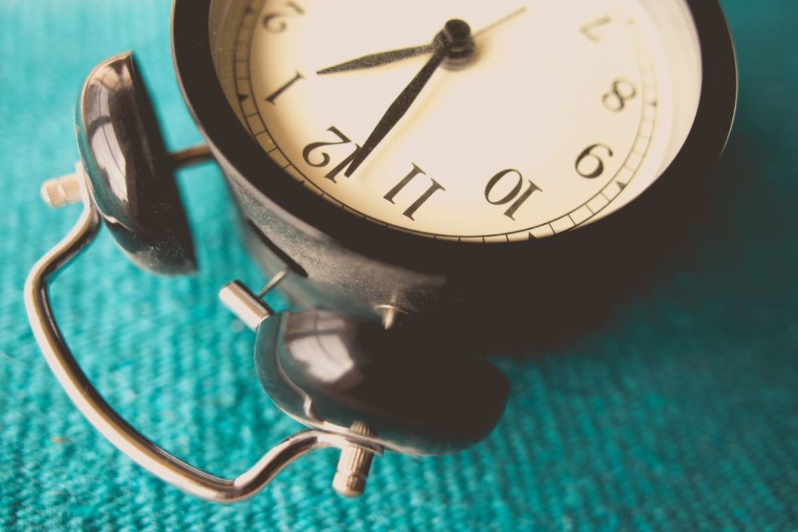 Alarm clock lying on green cloth